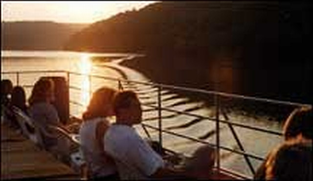 Couple on the top deck of the riverboat during sunset cruise