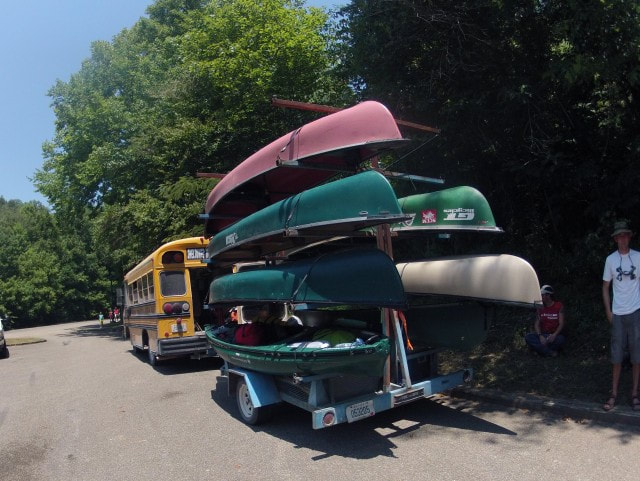 Bus and canoe trailer loaded with boats