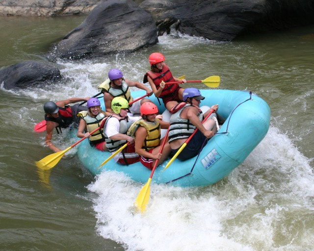 A group of whitewater rafters navigating their way through a tricky rapid. 