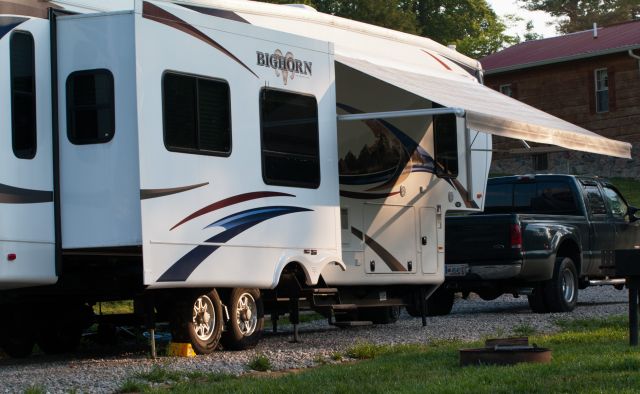 An RV pulled behind a truck. The RV is setup, awning has been extended, and is ready for their stay in one of our pull-through RV sites. 