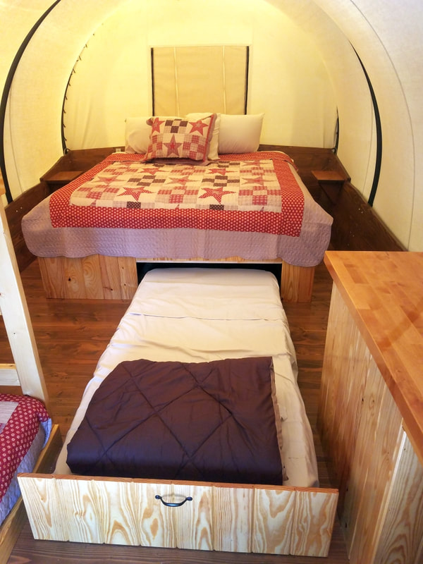 This photo shows our King sized bed in the Covered Wagons with the twin size trundle bed located underneath. 